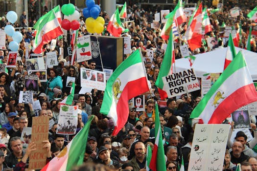 A peaceful protest in Vancouver advocating for human rights in Iran, featuring vibrant flags and diverse participants.