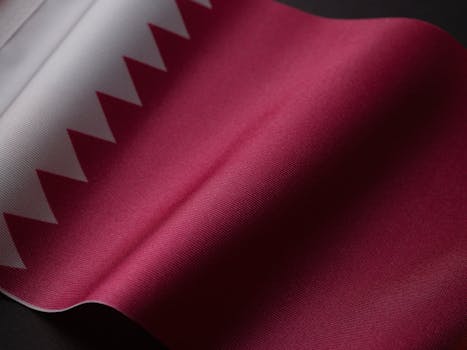 A detailed close-up of the Qatar national flag showcasing its unique design and colors.