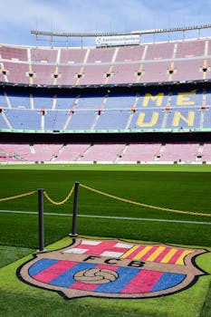 A clear daytime view of Camp Nou Stadium in Barcelona with iconic FCB logo on the field.