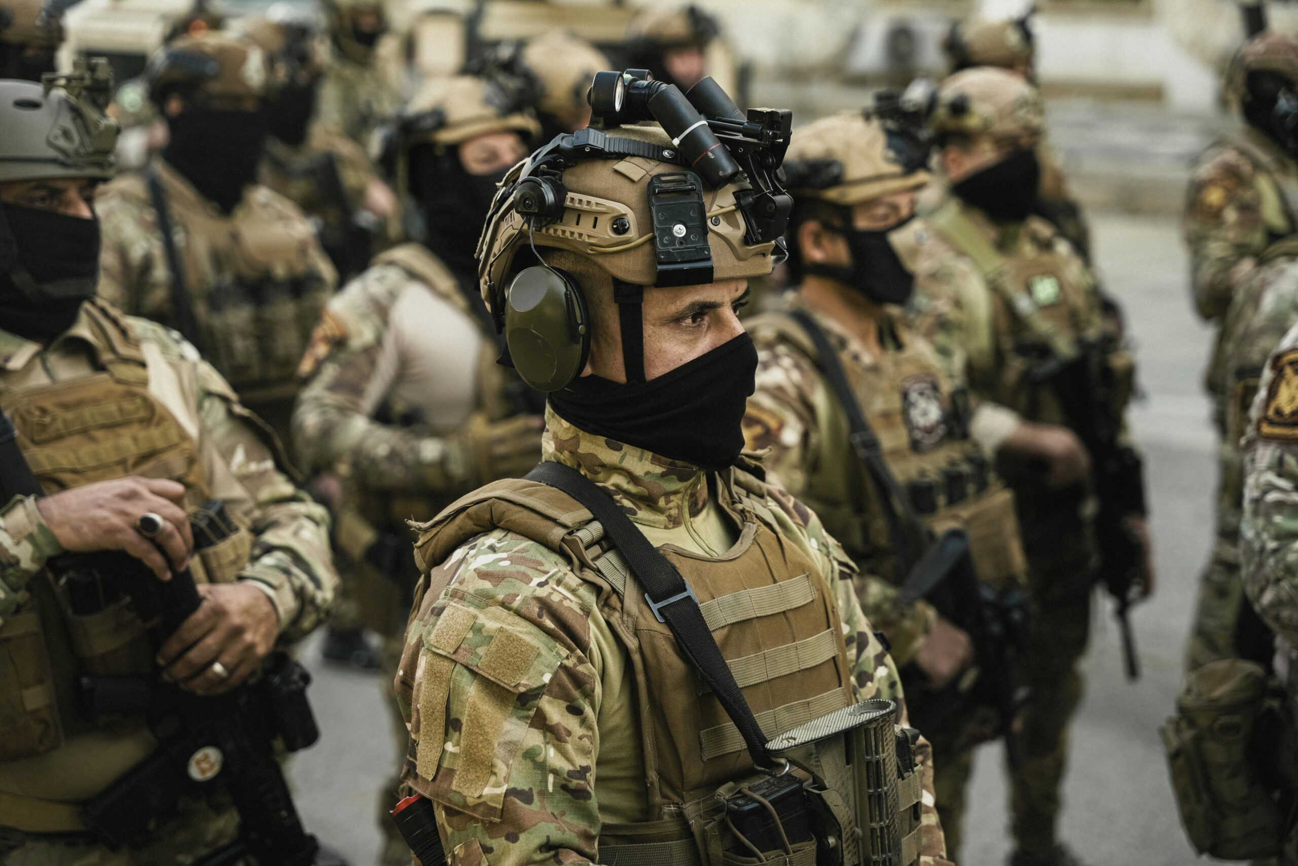 Group of soldiers in tactical gear standing in formation during a military operation.