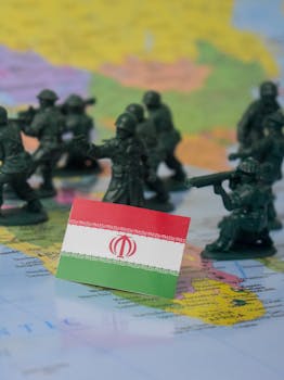 Toy soldiers and Iran flag on a world map symbolizing geopolitical tensions.
