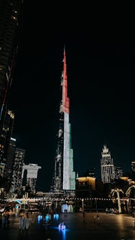 Stunning nighttime view of Burj Khalifa with colorful lights in Dubai's cityscape.