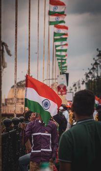 A man proudly holds the Indian flag during a patriotic event, showcasing national pride.