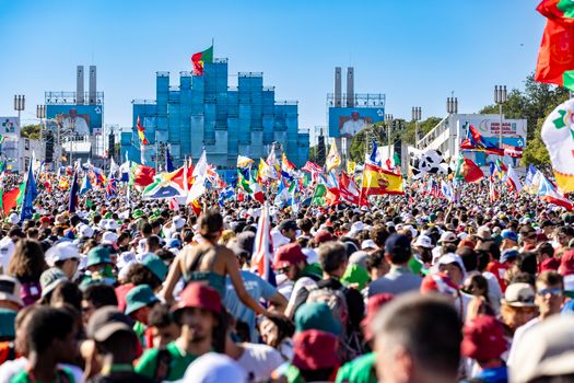 A colorful crowd gathers with flags for a lively celebration in Lisbon.