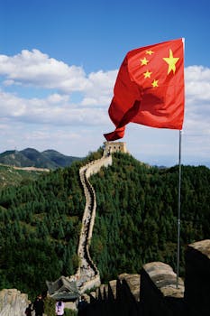 Scenic view of the Great Wall and Chinese flag under a clear blue sky, perfect for travel imagery.